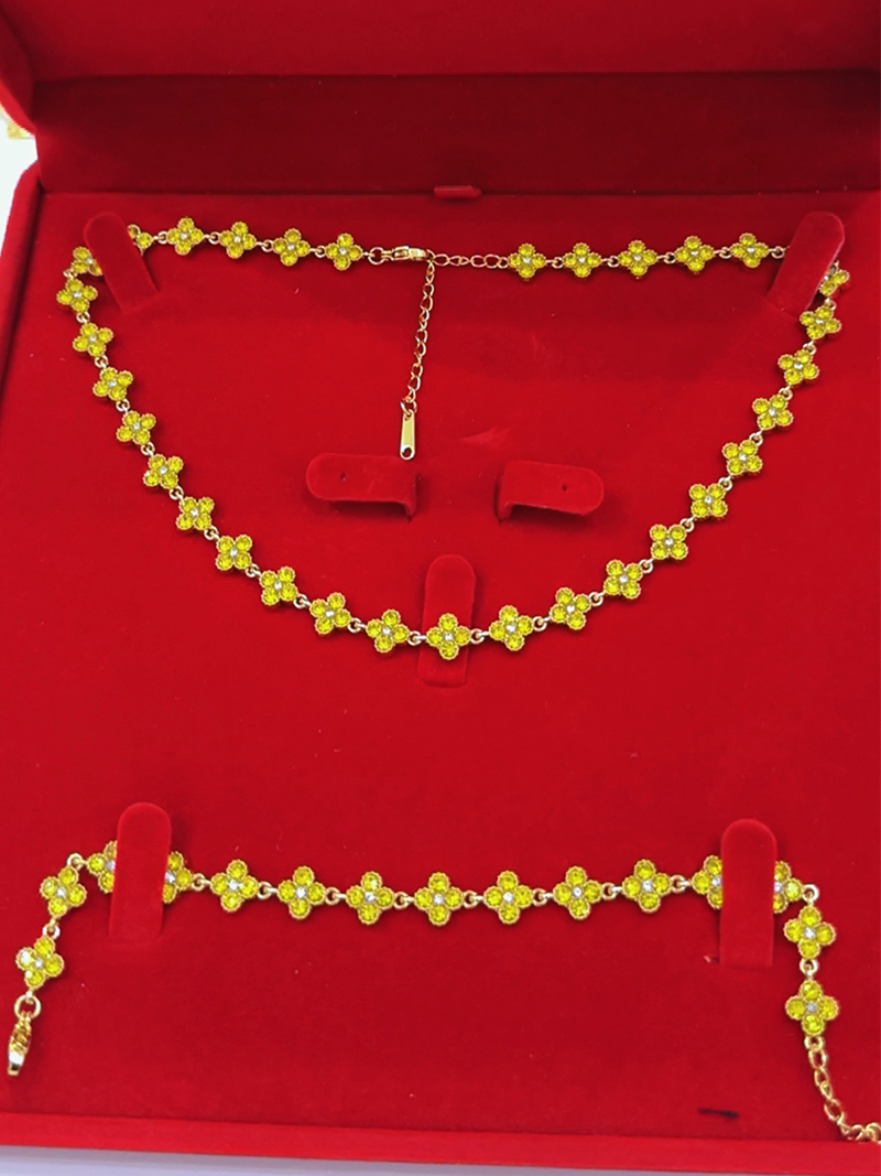 Parure (collier + bracelet + boucles d'oreilles) en chaîne dorée sertie de trèfles en cristaux jaune citron