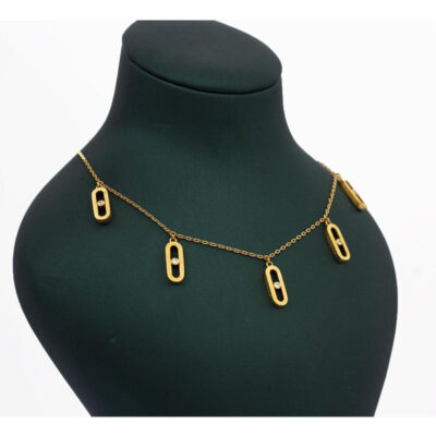 Collier chaîne dorée orné de breloques ovales ajourées (style maillon Move) serties d'un strass central, présenté sur buste