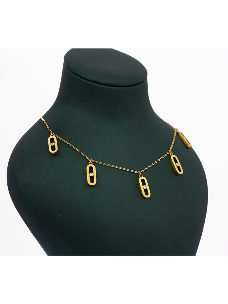 Collier chaîne dorée orné de breloques ovales ajourées (style maillon Move) serties d'un strass central, présenté sur buste